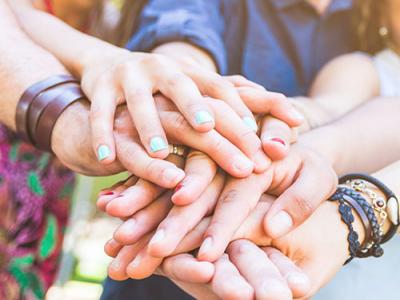 Closeup of employees with hands together