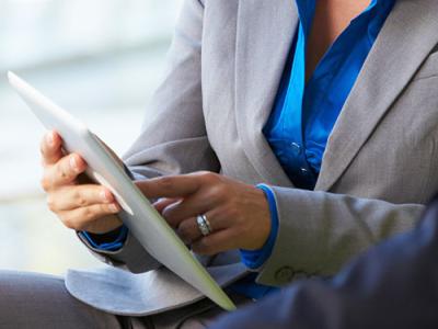 Closeup of lady showing man something on iPad