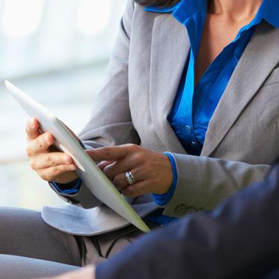 Closeup of lady showing man something on iPad