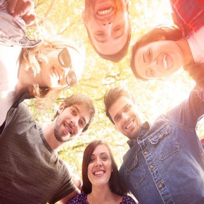 Small group of young employees huddling together