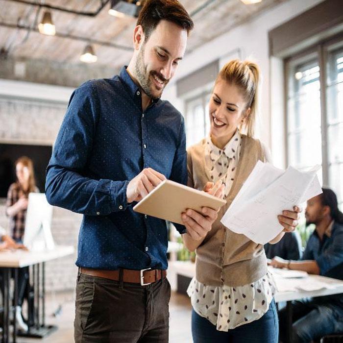 Young man and woman comparing notes on iPad
